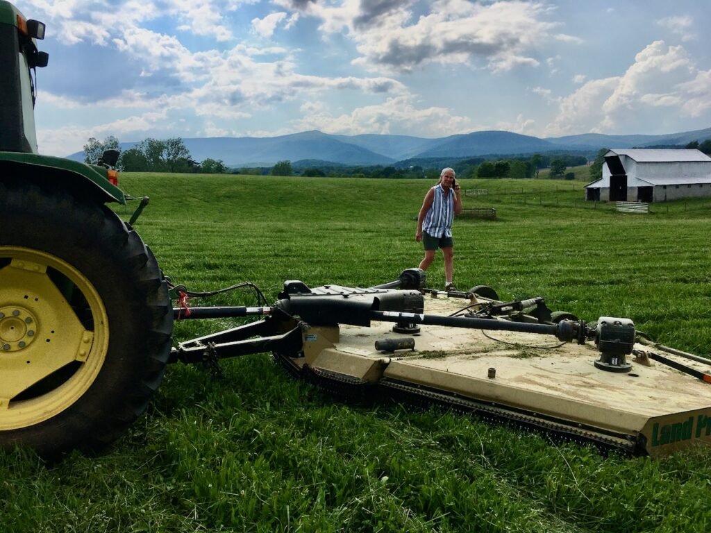 Clipping pasture with a 15-foot wide bat-wing rotary mower.
