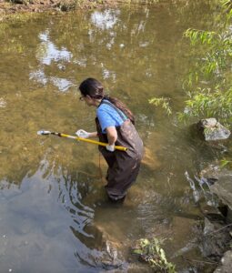 Bethany collecting water sample.